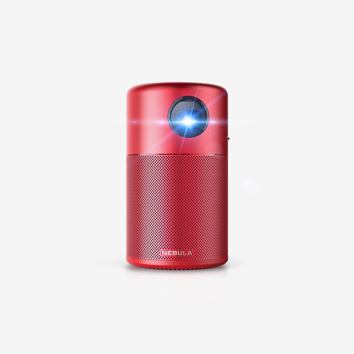 A red Nebula Capsule portable projector sits in a white room while projecting a blue light toward the camera.